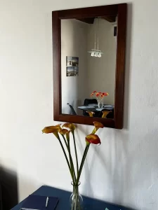 The inside of the apartment reflected in a wood framed mirror